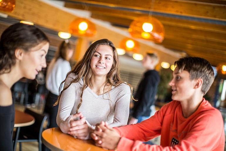Studenter diskuterar i skolans café