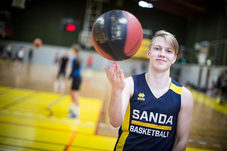 Basketkille som snurrar bollen på fingret.