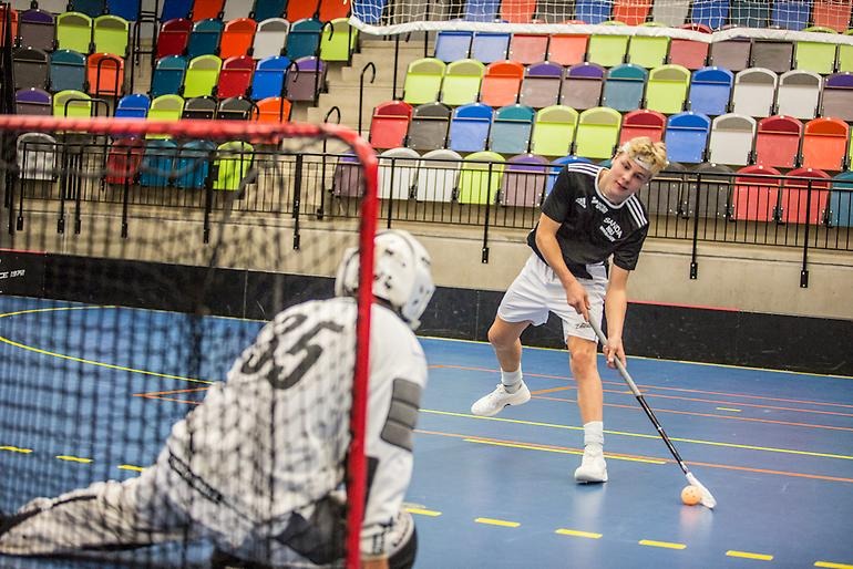 Innebandyspelare försöker göra mål från kanten.